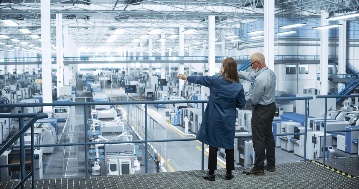 two business people in an industrial manufacturing plant